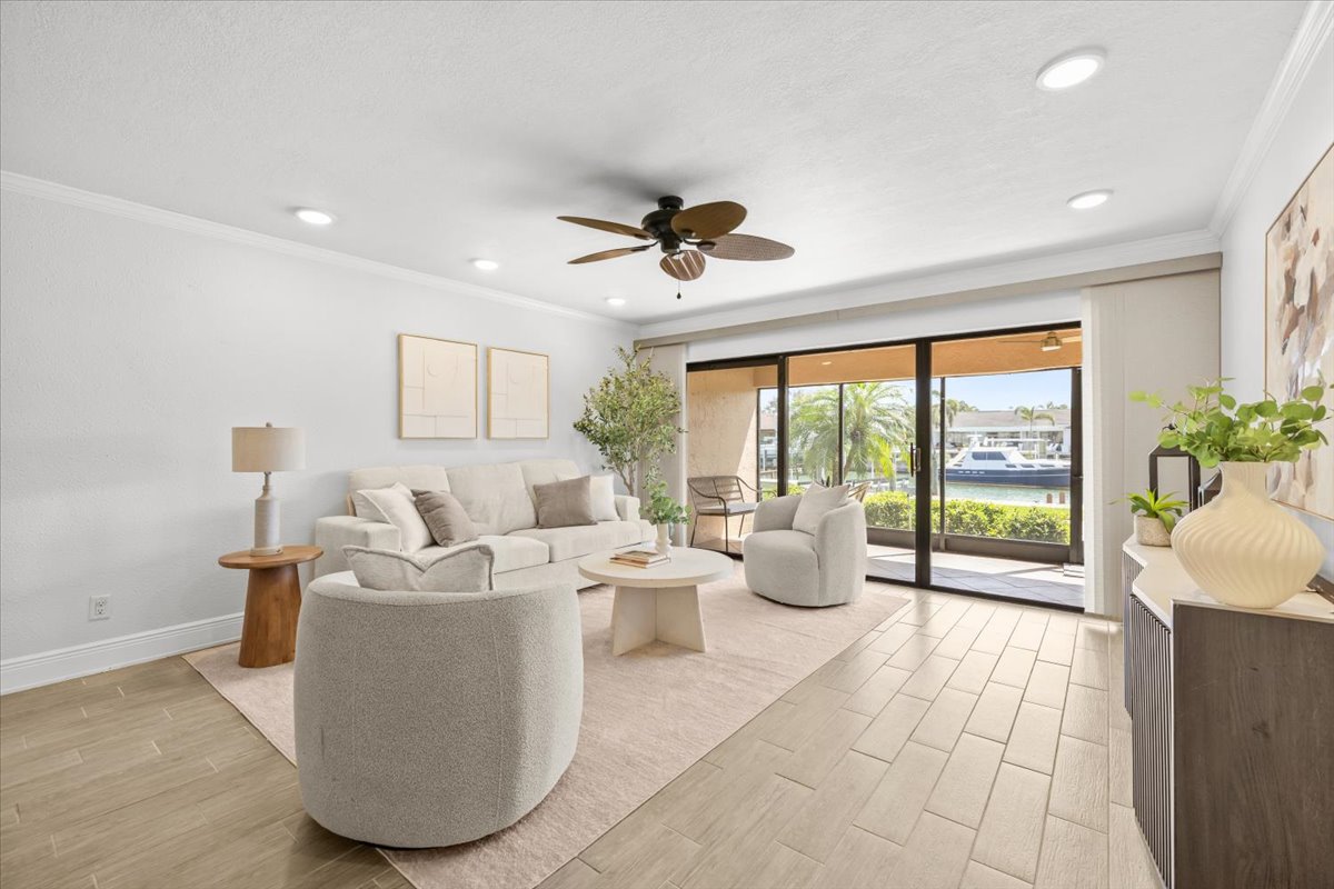 Living room with waterfront view through sliding doors, 4730 Brittany Dr S #36
