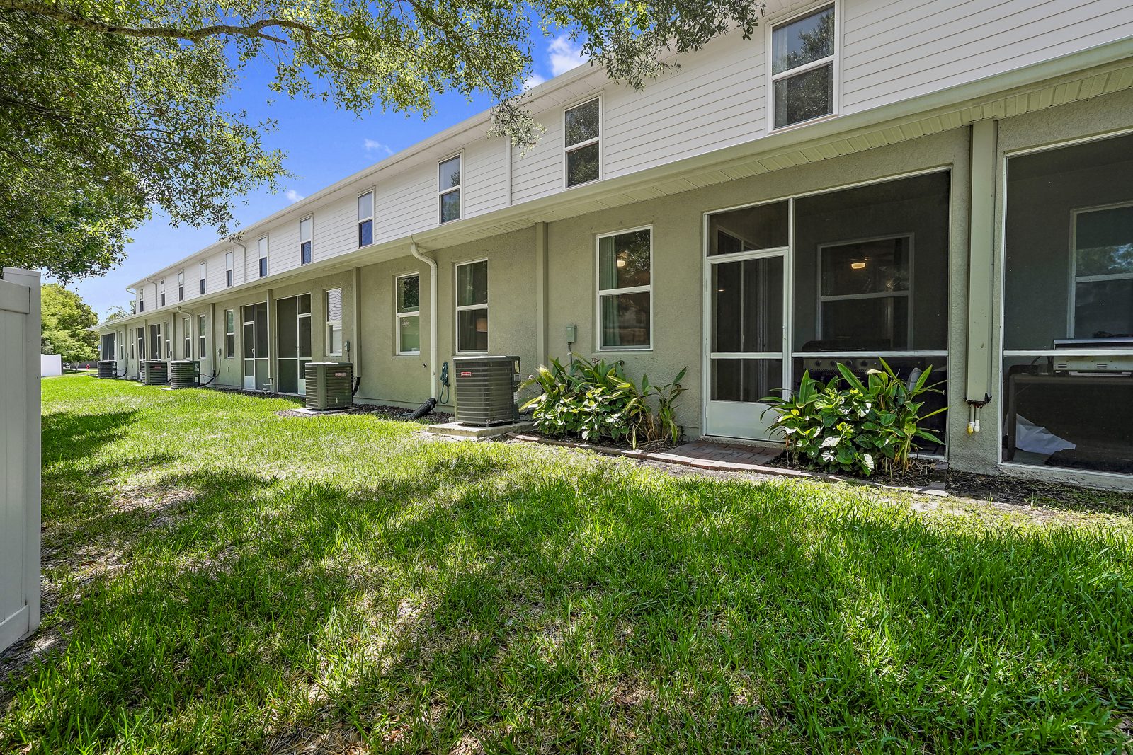 Rear exterior with screened patios backing to green space, 5246 Neil Dr